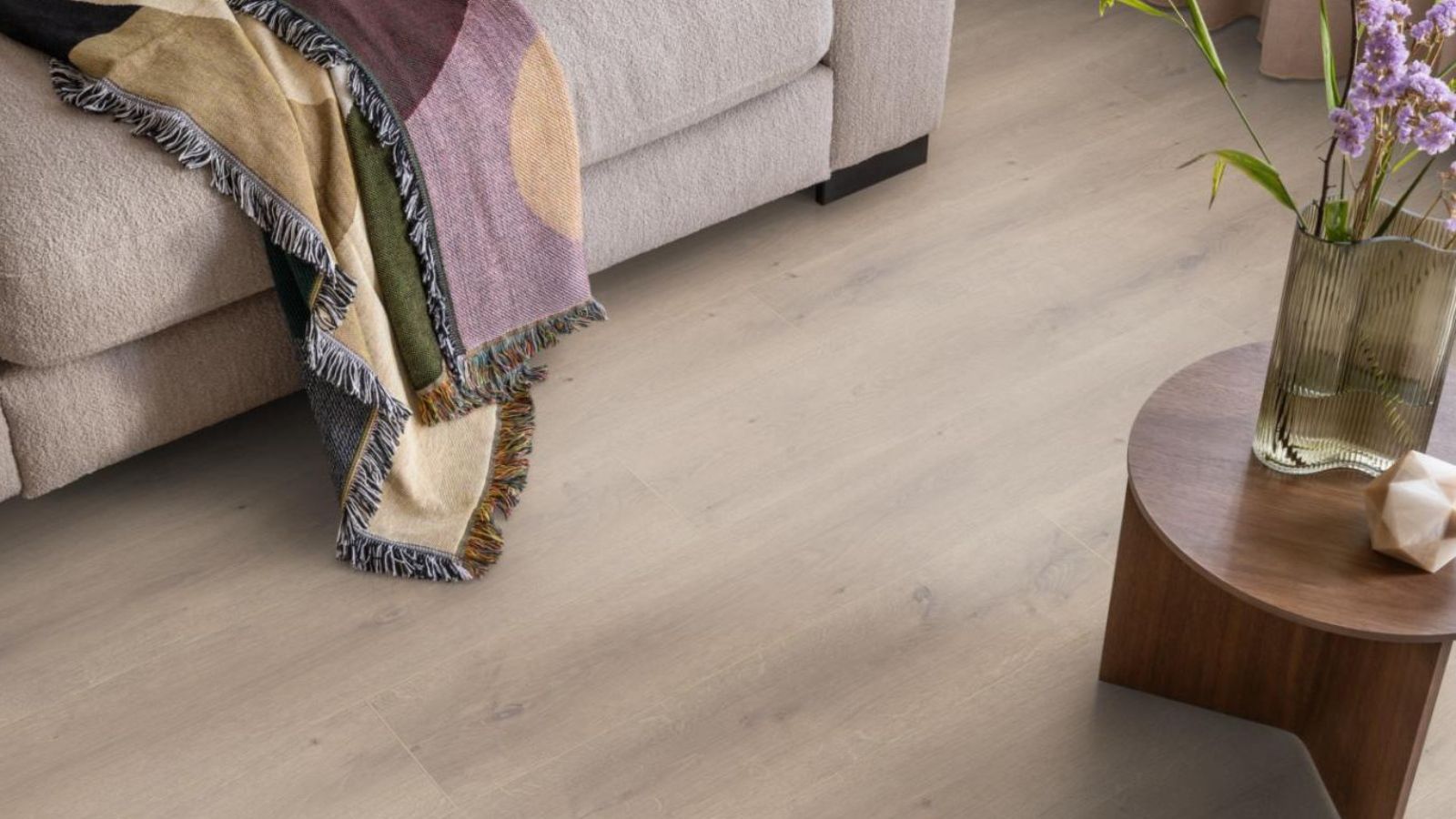 Moderne woonkamer met laminaatvloer in warme houtlook, als voorbeeld van een stijlvolle en onderhoudsvriendelijke vloer